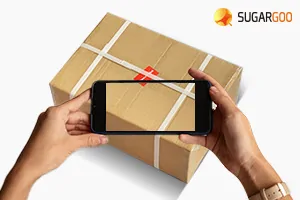 Sealed parcel being photographed by warehouse staff